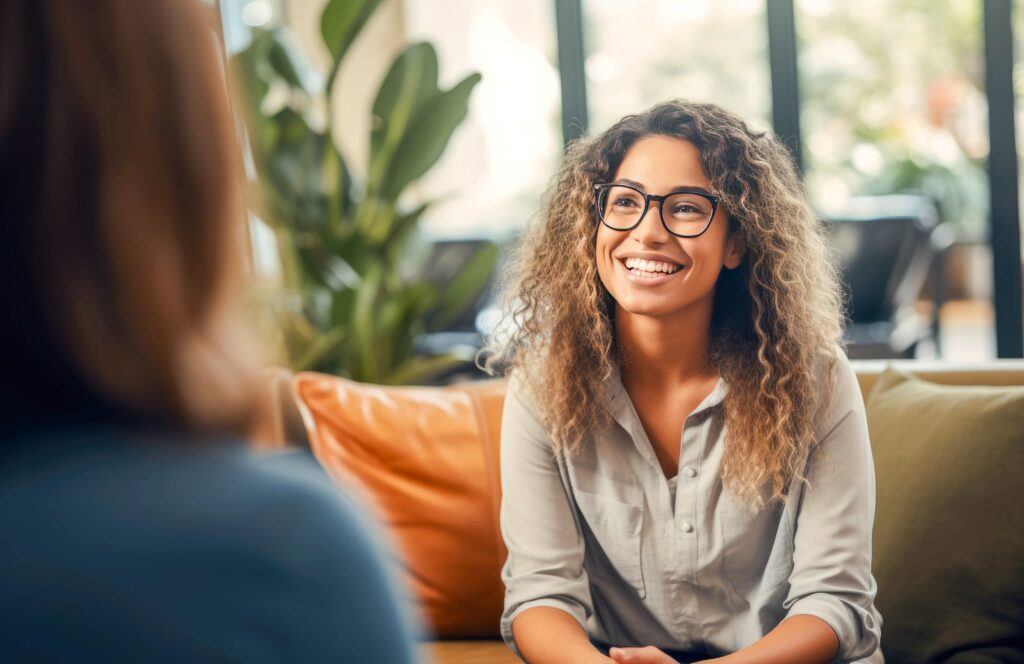 female with curly hair on sitting on a couch