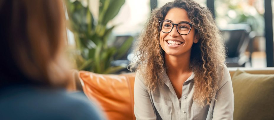 female with curly hair on sitting on a couch